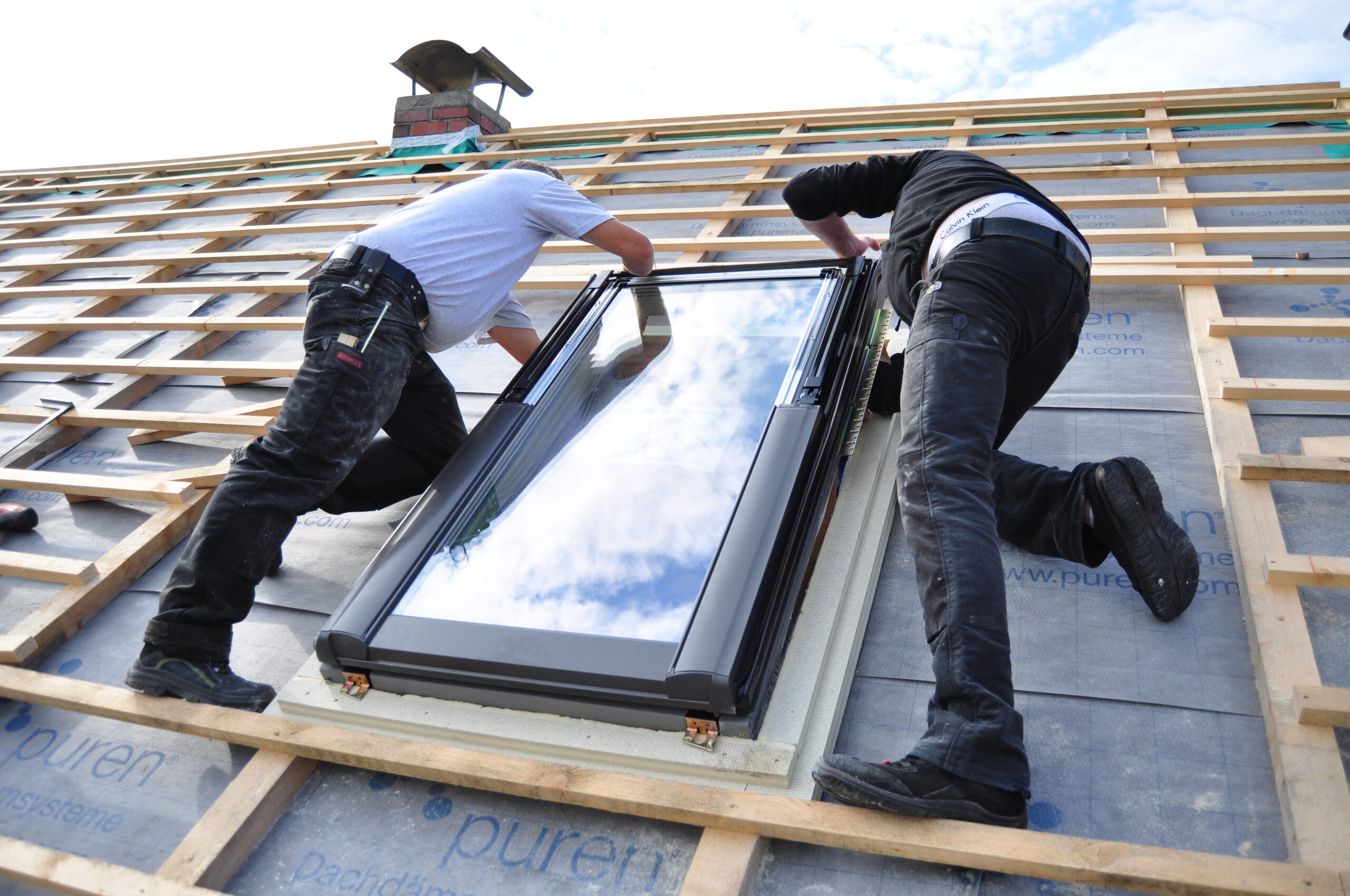 Two Men Assembling A Roof Skylight