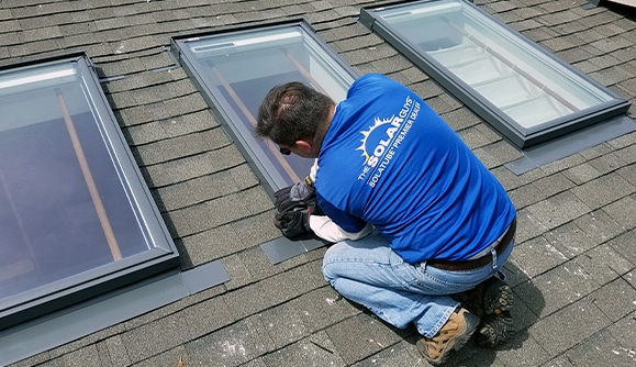 the solar guys on roof replacing a skylight